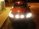2000 Ford Taurus - Red 2000 Ford Taurus sedan parked at night with its lights illuminated.
