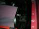 1994 Ford Bronco - Close-up of a K&N air filter assembly attached to a red vehicle's fender.