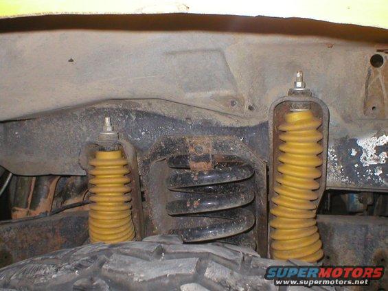 Front suspension with yellow shocks and black coil springs visible near tire