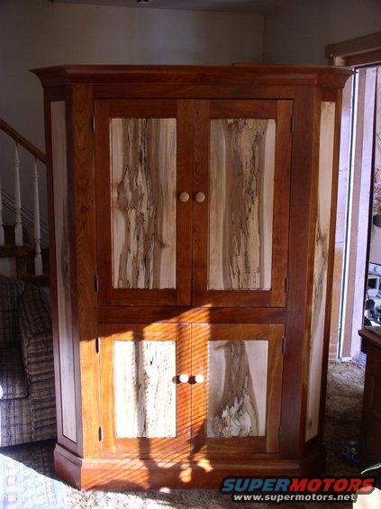 Wooden cabinet with two upper doors and two lower doors, natural wood grain patterns