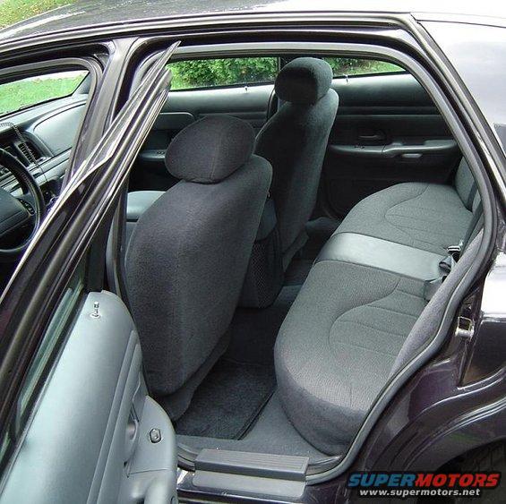 Back seat and door panel of a car. Dark gray cloth seats and gray door trim