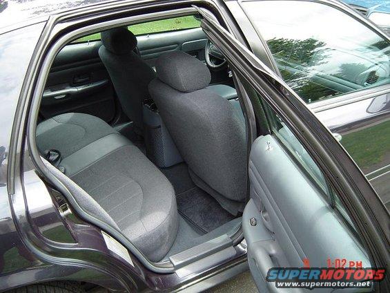 Interior view of dark sedan with open doors showing rear seats and dashboard