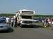 1990 Jeep YJ - A motorhome is parked at an outdoor event with several people standing nearby.