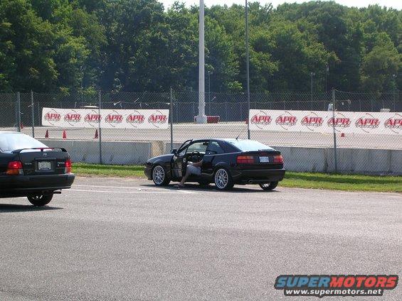 Black Volkswagen Corrado with driver's door open, parked on asphalt. Another black car is visible to the left