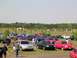 1990 Jeep YJ - A gathering of cars and people in an open field on a sunny day.