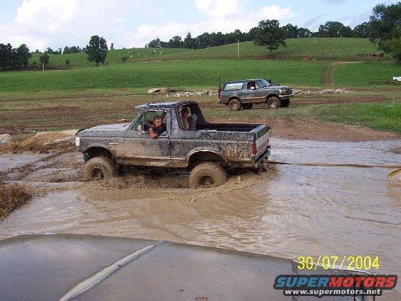 Ford Bronco stuck in mud with another Bronco in the background