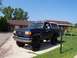 1989 Ford Bronco - This lifted Ford Bronco is parked in front of a house on a sunny day.