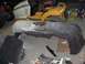 1993 Ford Probe - A car bumper, possibly for a 1993 Ford Probe, sits on the floor surrounded by other parts and lawnmowers.