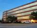 2000 Ford Crown Victoria - A white sedan is parked in front of a modern office building during sunset.