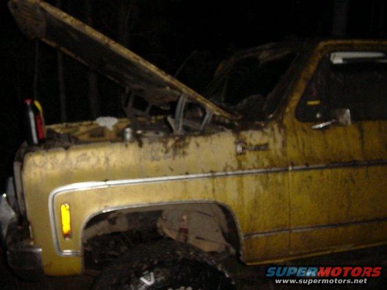 Yellow pickup truck, heavily weathered, with hood open, showing engine detail. Front quarter view