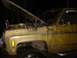1989 Ford Bronco - This weathered yellow pickup truck, seen from the front quarter angle, has its hood open, revealing the engine compartment.