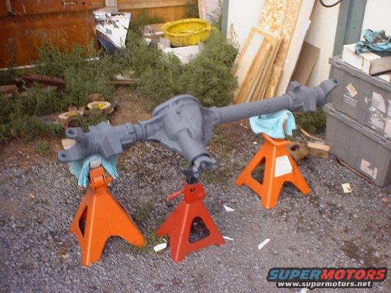 Gray rear axle assembly on orange and red jack stands