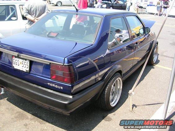 Blue sedan, possibly a Volkswagen Jetta, with custom wheels and a "TORQUE" badge on the rear. License plate reads GGS 555