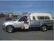 1986 Ford Bronco - A silver pickup truck with a camper shell displays "AIM Electrical & Plumbing Services" and a phone number on its side.