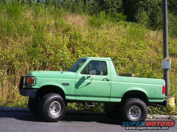 Green 1990 Ford Bronco parked on the side of the road