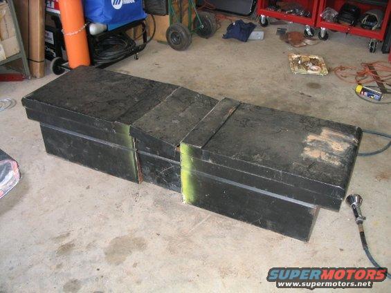 Three black metal toolboxes on a concrete floor in a garage