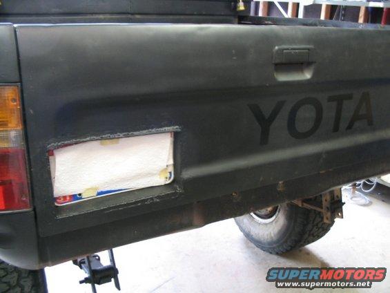 Black pickup truck tailgate with YOTA lettering and license plate cutout