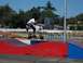 1990 Ford Bronco - Rider on a motorized scooter performs a jump over a ramp at an outdoor track.