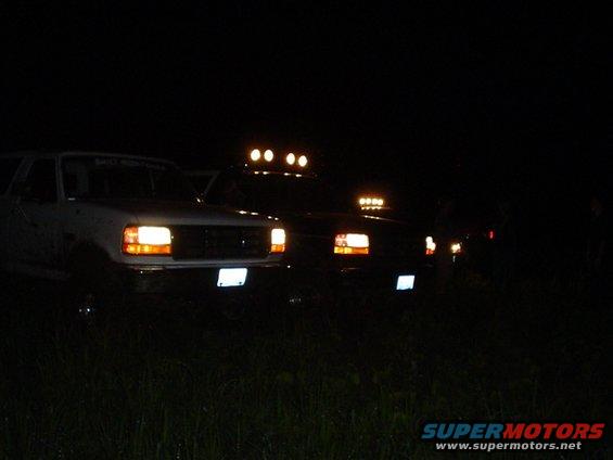 Front view of white truck with light bar at night