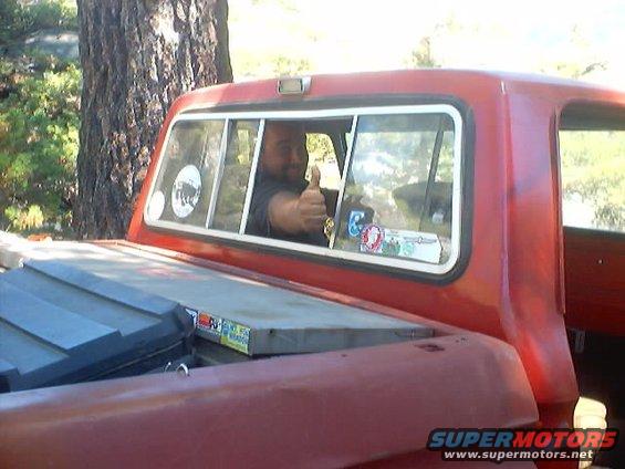 Red 1976 Ford F-100 rear view with man giving thumbs up