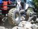 1976 Ford F-100 - A modified off-road vehicle tackles a challenging rocky trail with its large tires.