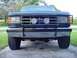 1988 Ford Bronco - The front of a dark blue Ford Bronco is shown, equipped with a heavy-duty brush guard and fog lights.