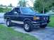 1988 Ford Bronco - This 1987 Ford Bronco features a two-tone paint job and a spare tire mounted on the rear.