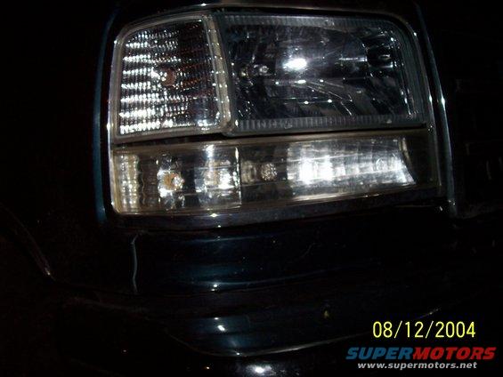 Dark green 1992 Ford F-150 headlight assembly with chrome trim. Date stamp 08/12/2004