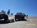 1976 Ford F-100 - Two trucks are parked on a rocky terrain under a clear blue sky.