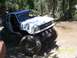 1976 Ford F-100 - This modified SUV navigates a challenging off-road course with large tires and auxiliary lights.