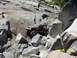 1976 Ford F-100 - An off-road vehicle tackles a challenging rocky terrain with people observing.