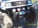 1976 Ford F-100 - A modified truck with oversized tires and auxiliary lights is seen off-road.