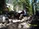 1976 Ford F-100 - A modified truck navigates a rocky trail in a wooded area.
