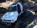 1976 Ford F-100 - Off-road vehicle with large tires navigating a rocky terrain.