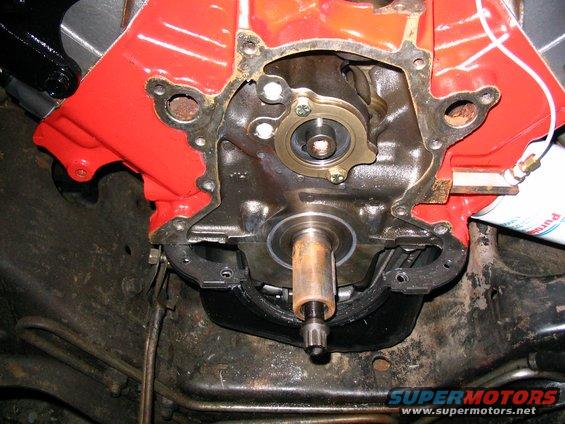 Engine timing chain cover with visible shaft and bolts