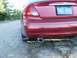 2000 Ford Taurus - The rear of a red 2000 Ford Taurus is visible, with a Michigan license plate and exhaust pipe.
