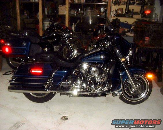 Blue motorcycle with chrome engine and saddlebags, parked indoors