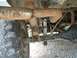 1979 Ford F-150 - Undercarriage view of a truck's rear axle and suspension system, showing leaf springs and a shock absorber.