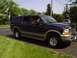 2000 Ford Excursion - A dark blue 2000 Ford Excursion is parked on a driveway with a white SUV in the background.