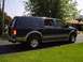 2000 Ford Excursion - A dark blue and tan 2000 Ford Excursion is parked on a paved driveway with a grassy lawn in the foreground.