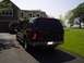 2000 Ford Excursion - Rear view of a dark 2000 Ford Excursion parked in a driveway, with a red SUV visible behind it.