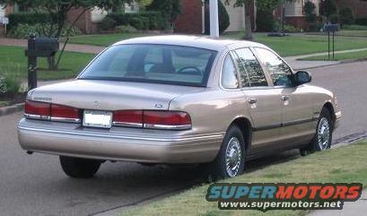 Tan 1995 Ford Crown Victoria parked on a residential street, rear 3/4 view