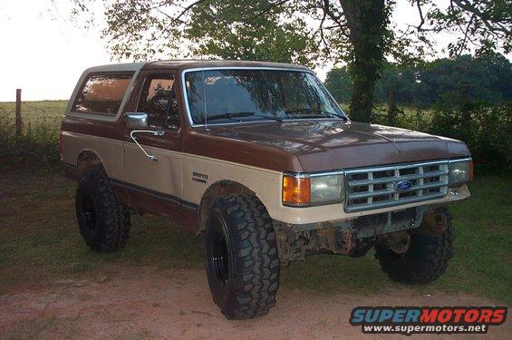 Brown and tan 1987 Ford Bronco with large off-road tires parked outdoors