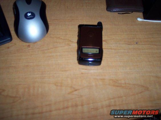 Flip phone and computer mouse on a wooden desk