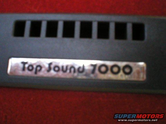 Close-up of a 'Top Sound 7000' badge on a car's interior trim