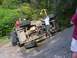 1990 Ford Bronco - Off-road vehicle overturned on rocky terrain, with people trying to recover it.