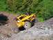 1990 Ford Bronco - This heavily modified off-road vehicle navigates a challenging rocky incline, its robust suspension and protective roll cage.