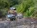 1990 Ford Bronco - Multiple off-road vehicles navigate a challenging rocky terrain on a sunny day.