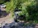 1990 Ford Bronco - An off-road buggy tackles a challenging rocky incline, with a pickup truck and onlookers observing the action.