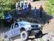 1990 Ford Bronco - Toyota Tacoma navigates a rocky trail with spectators observing the off-road action.
